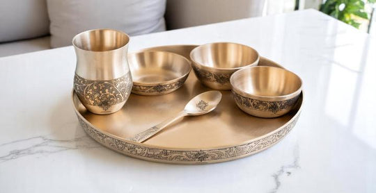 Indian Art Villa bronze thali set with glass, bowls, and spoon, elegant handcrafted dinnerware for traditional dining.