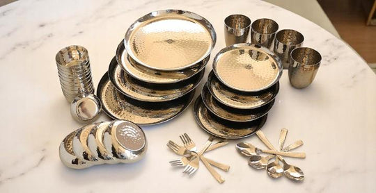 Premium hammered stainless steel dinner set by Indian Art Villa, includes plates, bowls, glasses, forks, and spoons.
