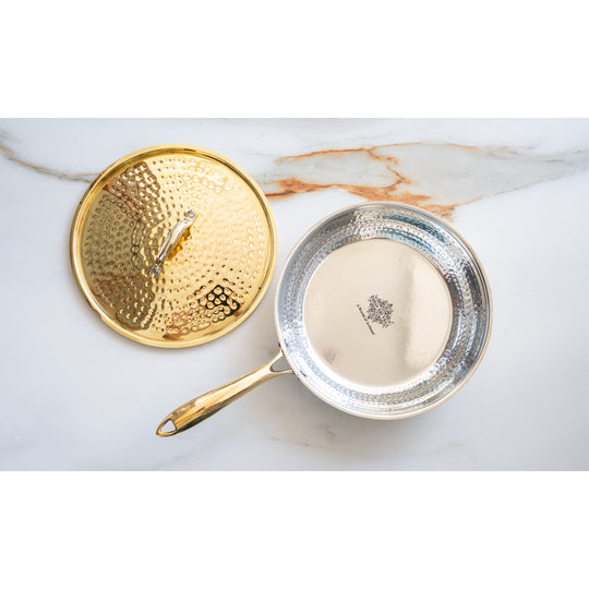 Heavy brass cooking pan with hammered top lid extended rod handle smooth radiant body and tin coated interior lining
