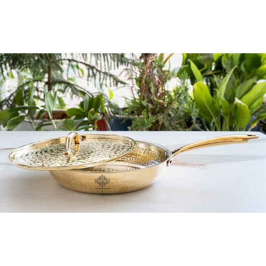 Decorative brass pan with circular hammered cover slim polished handle radiant metallic body and lined tin interior
