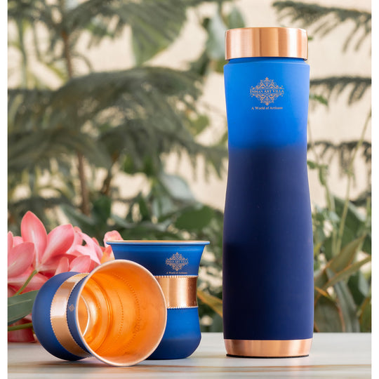 Artisan blue copper bottle set with glasses, smooth matte texture for dining and festive gifting