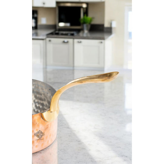 Elegant hammered copper saucepan featuring a brass handle, designed for both style and utility