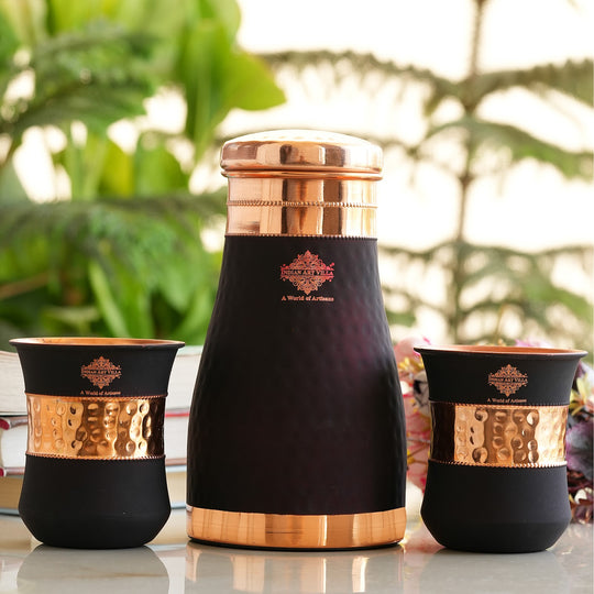Stylish and functional black copper bottle and glass set with hammered accents by Indian Art Villa for your home.