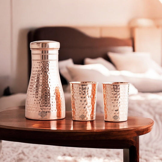 Luxurious hammered copper drinkware set, featuring a bottle and tumblers, perfect for décor and daily use.