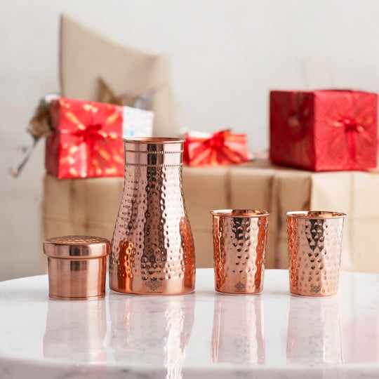Luxurious hammered copper drinkware set, featuring a bottle and tumblers, perfect for décor and daily use.