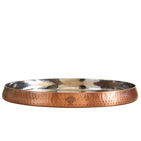 Decorative copper plate with hammered texture and graceful curved edges ideal for table presentations.