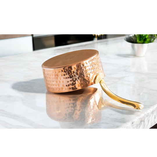 Unique copper cookware with a hammered texture and brass handle, ideal for enhancing your kitchen collection.
