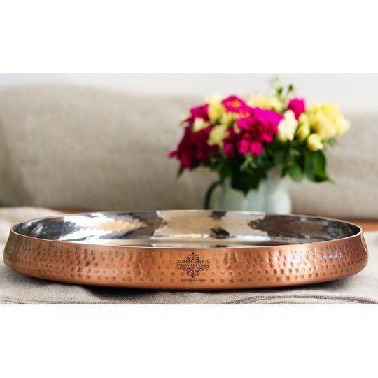 Stylish hammered copper plate with curved borders perfect for serving delicacies and table decor with IAV