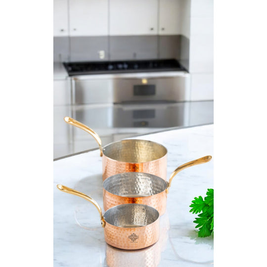 Timeless copper cookware with a handcrafted hammered texture and a comfortable brass handle for easy use.