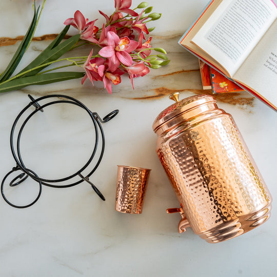 Angle of 5L round copper matka on stand showing spherical body on stable iron legs – copper water pot with stand
