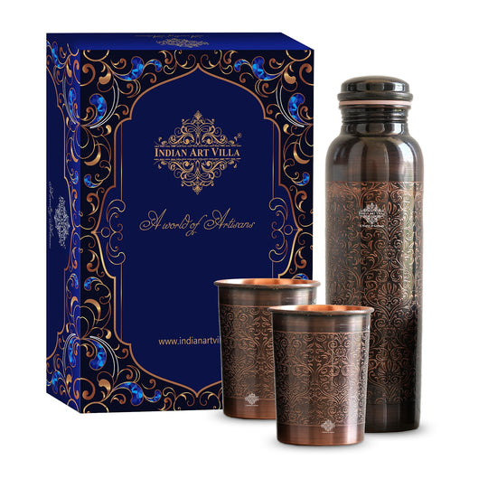 Antique copper water bottle with embossed floral design, paired with matching glasses in a softly lit home environment.