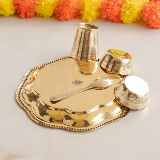 Set of gold-colored Brass utensils including a Small Plate, Glass, and a spoon on a light background.