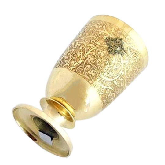 Flower embossed brass glass supports spiritual wellness by offering water for rituals that balance mind body and spirit
