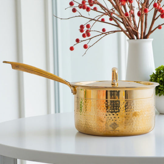 Elegant brass sauce pan with hammered body tin coated lining matching brass lid and long straight handle attached to side