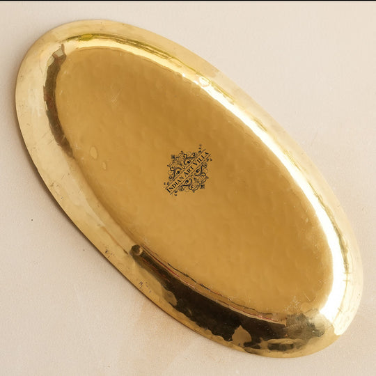 Handmade oval brass platter with smooth hammered surface designed for Indian serveware display and meal settings