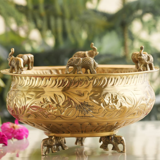 Decorative gold bowl with elephant figures on a blurred natural background