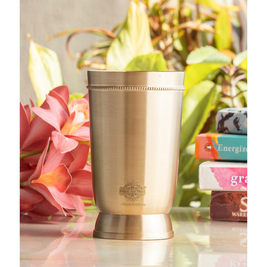 Elegant brass tumbler with a matte texture and sturdy base designed for an upscale drinking experience.