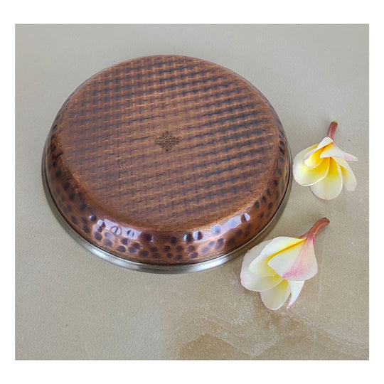 Polished copper steel thali with hammered design perfect for showcasing rice halwa at housewarming parties.