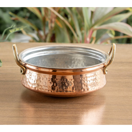 Hammered copper pot with tin interior lining and handle, ideal for both serving and home decoration.