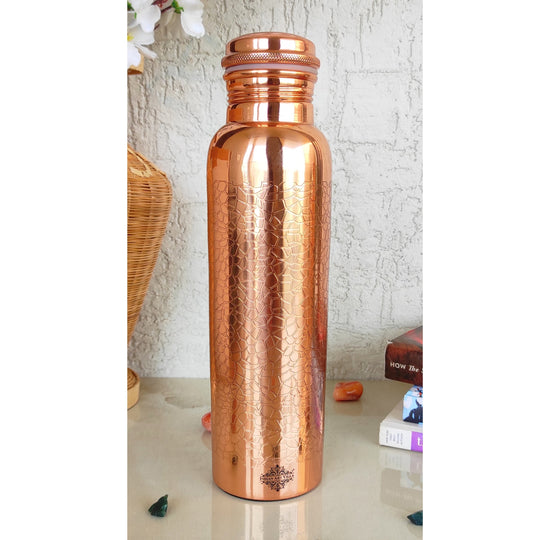 Handcrafted copper metal water bottle with delicate floral engravings, a signature creation by Indian Art Villa artisans.