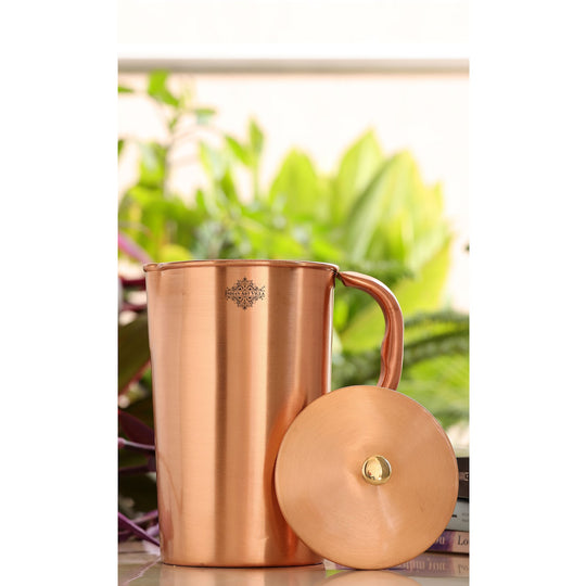 A beautiful copper jug, bottle, and glass set with a lacquered finish, perfect for any occasion.