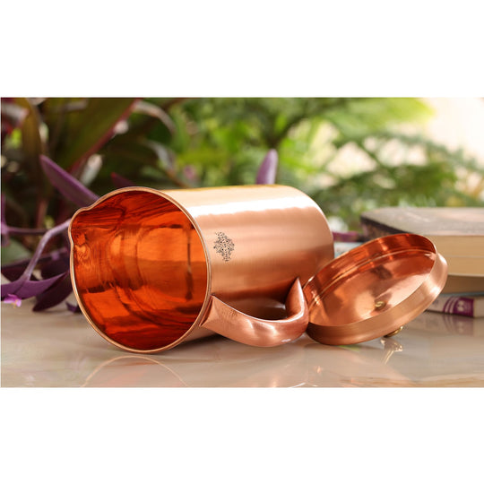 A beautiful copper jug, bottle, and glass set with a lacquered finish, perfect for any occasion.