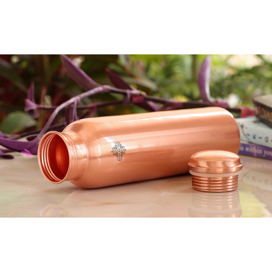 A beautiful copper jug, bottle, and glass set with a lacquered finish, perfect for any occasion.