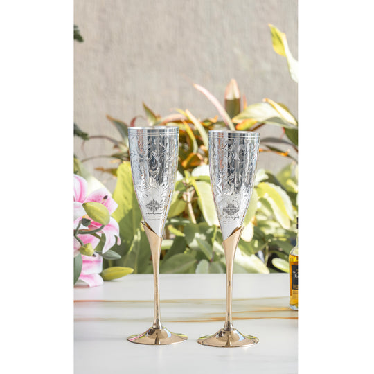 Two decorative champagne flutes on a table with a floral background