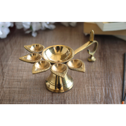 Brass aarti diya with deepak holders in a floral design, used for traditional Hindu rituals and puja ceremonies.