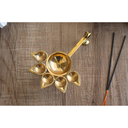 Brass aarti diya with deepak holders in a floral design, used for traditional Hindu rituals and puja ceremonies.