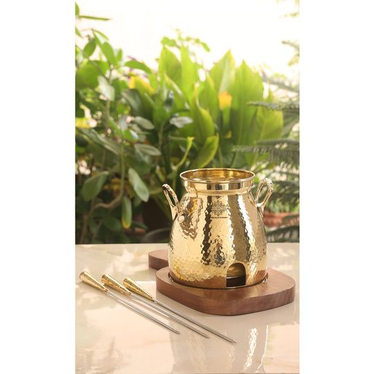 Elegant hammered brass tandoor with sturdy wooden base and three skewers ideal for festive and dining occasions