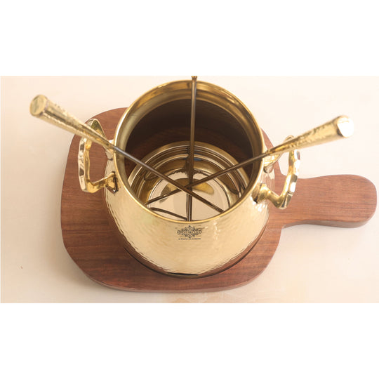 Tabletop brass tandoor with hammered texture wooden base and three skewers crafted in a traditional round vessel form