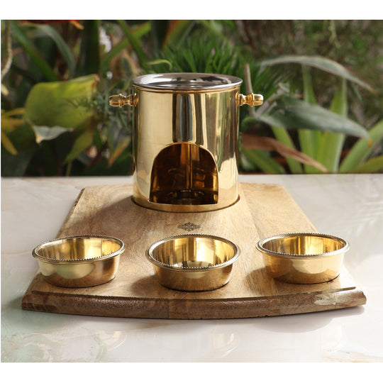 Brass food warmer with wooden tray and steel lid perfect for keeping curries or dal hot during festive family dinners