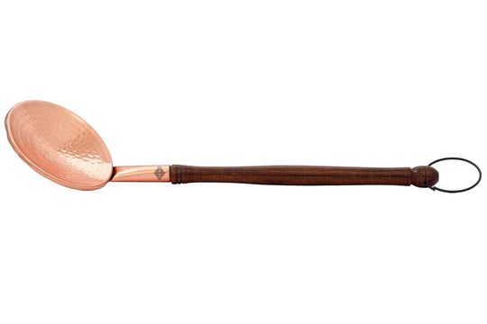 Handcrafted copper serving spoon with wooden handle and ring perfect for formal dinners or casual meals.